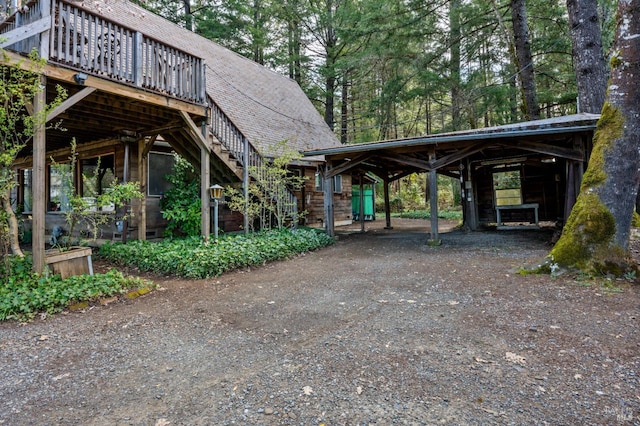 surrounding community featuring a carport, stairs, and dirt driveway