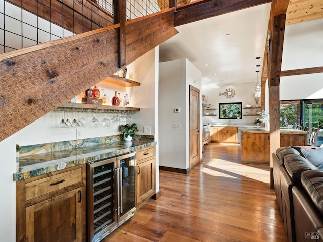 bar with baseboards, wine cooler, recessed lighting, bar, and light wood-style flooring
