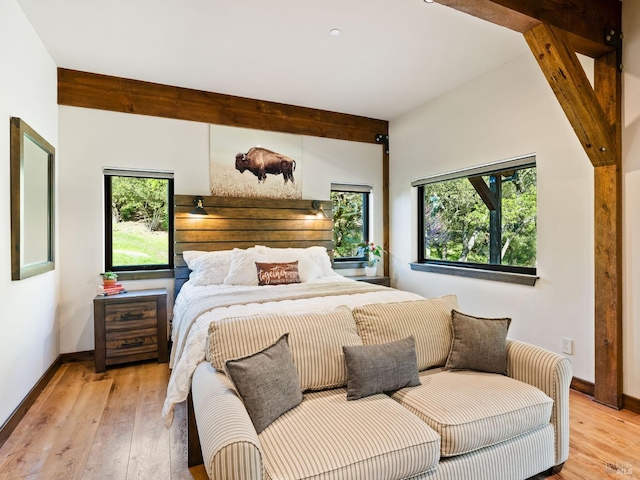 bedroom featuring light wood-style floors, baseboards, and multiple windows