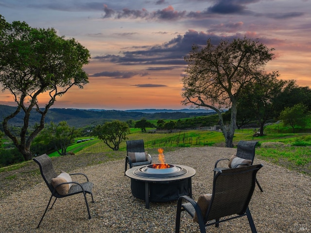 patio terrace at dusk with a mountain view and a fire pit