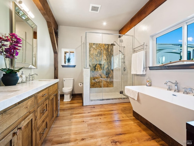 full bathroom with a shower stall, visible vents, toilet, wood finished floors, and a sink