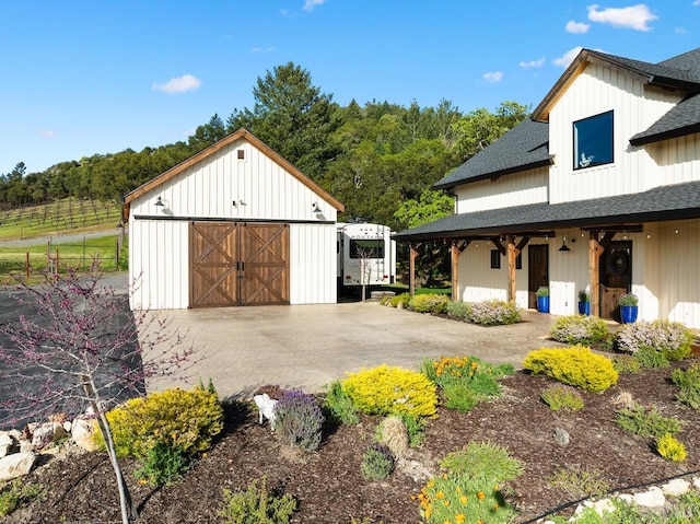 exterior space featuring an outbuilding, driveway, and fence