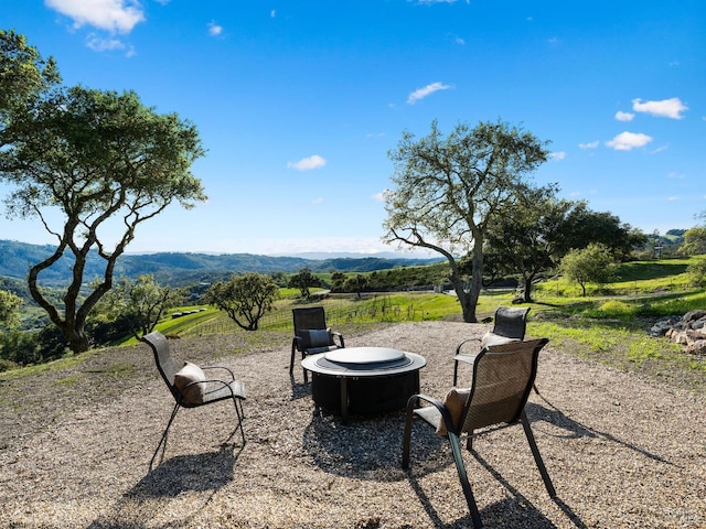 view of yard with a patio, a mountain view, and a fire pit