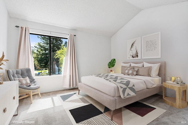 carpeted bedroom with vaulted ceiling and a textured ceiling