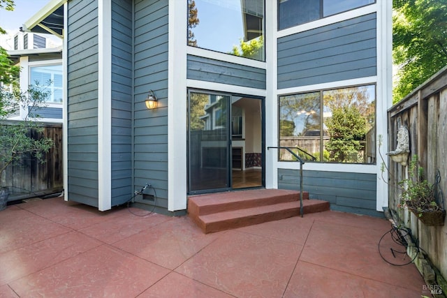 property entrance featuring fence and a patio