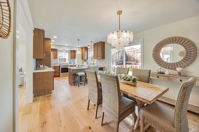 dining room with light wood-style flooring, a notable chandelier, and recessed lighting