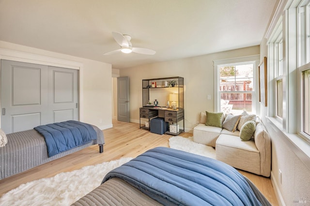bedroom with wood finished floors, baseboards, and a ceiling fan