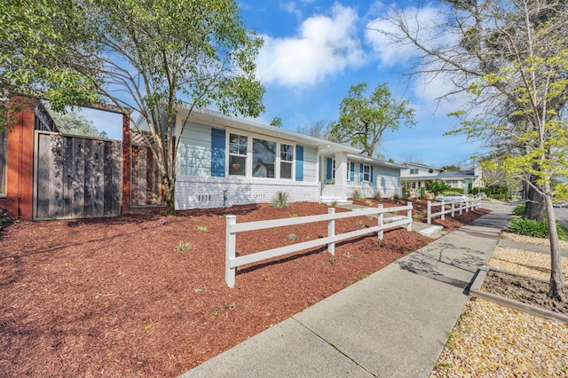 single story home featuring crawl space, fence, and brick siding