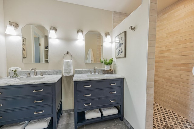 full bath featuring a sink, walk in shower, two vanities, and tile patterned flooring