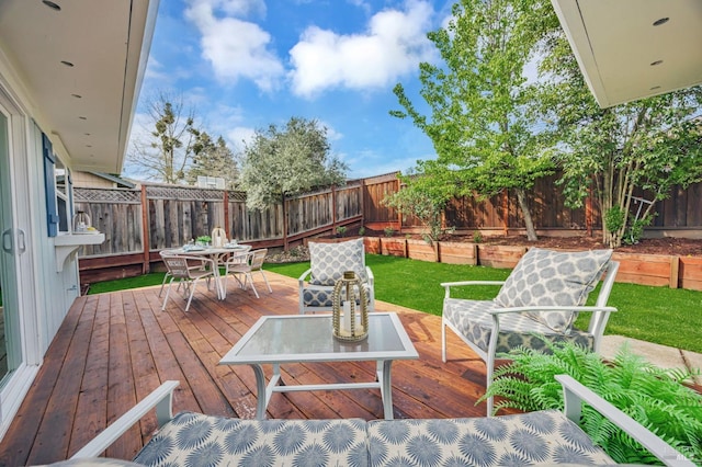 view of yard featuring outdoor dining area, a fenced backyard, and a wooden deck