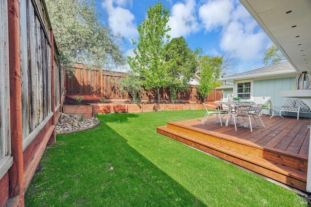 view of yard featuring outdoor dining area, a fenced backyard, and a wooden deck