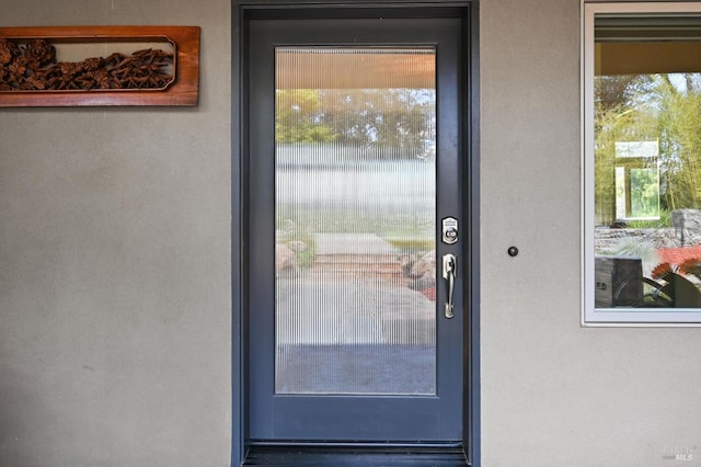 view of exterior entry featuring stucco siding