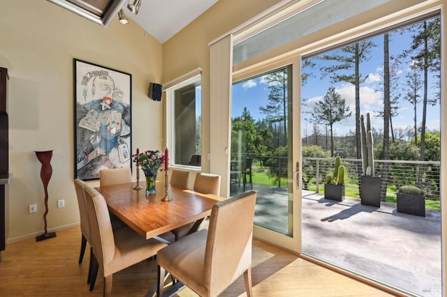 dining space featuring light wood-type flooring and baseboards
