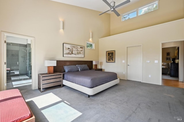 carpeted bedroom with ensuite bathroom and a towering ceiling