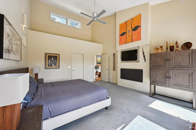 carpeted bedroom featuring a high ceiling and a ceiling fan