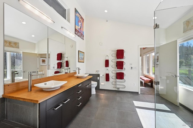 full bathroom featuring a freestanding tub, a high ceiling, toilet, recessed lighting, and vanity