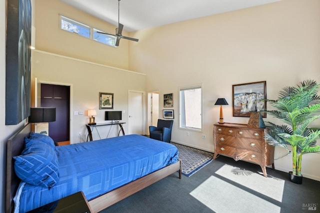 bedroom with ceiling fan, a towering ceiling, baseboards, and carpet floors