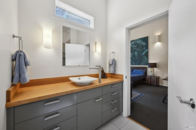 ensuite bathroom with tile patterned floors, vanity, and ensuite bath