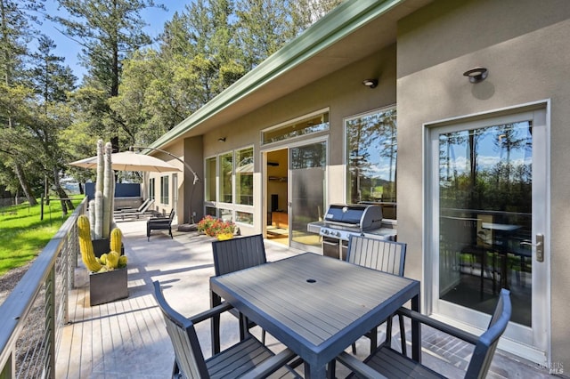 wooden terrace with outdoor dining area and grilling area