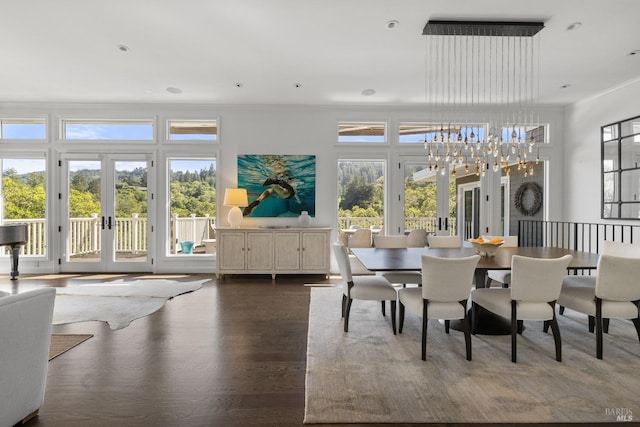 dining area featuring a chandelier, ornamental molding, french doors, and wood finished floors
