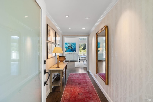 corridor featuring baseboards, ornamental molding, and dark wood-type flooring