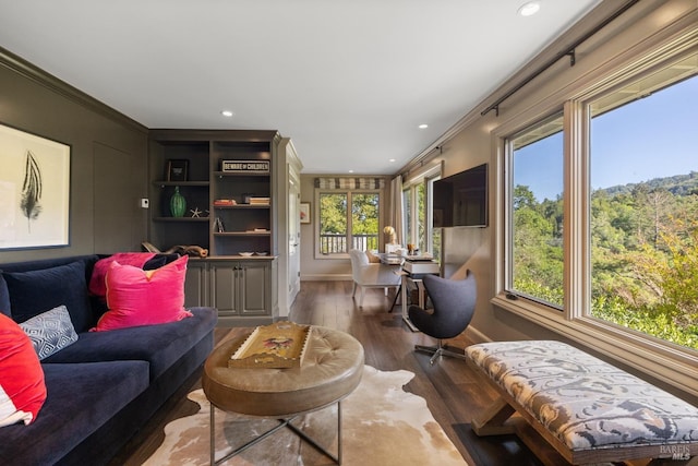 living area with recessed lighting, baseboards, ornamental molding, and wood finished floors