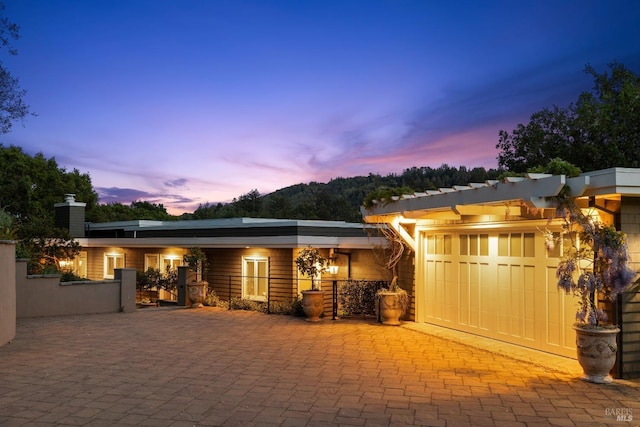 view of patio / terrace with a garage and decorative driveway