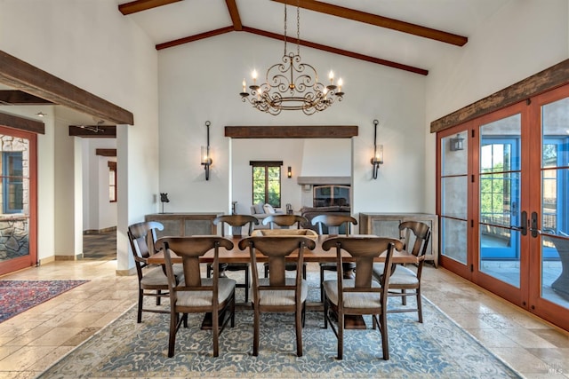 dining space with a chandelier, french doors, stone tile flooring, beamed ceiling, and high vaulted ceiling