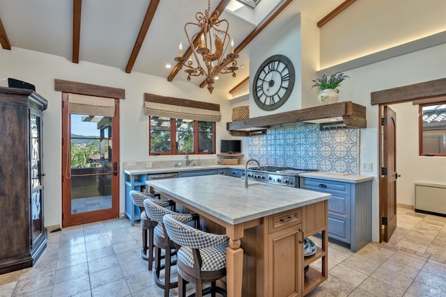 kitchen featuring an inviting chandelier, tasteful backsplash, a sink, a breakfast bar area, and beam ceiling
