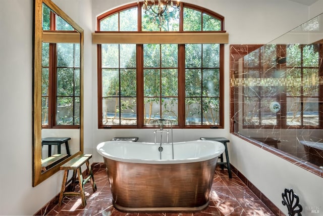 full bathroom with baseboards, marble finish floor, and a soaking tub
