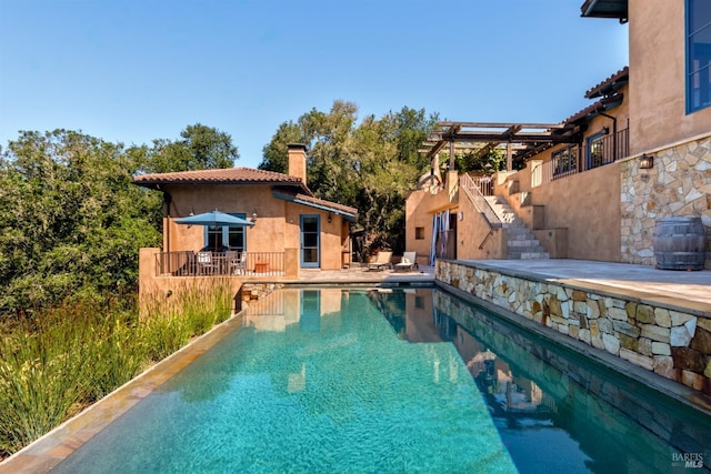 pool featuring stairway and a patio