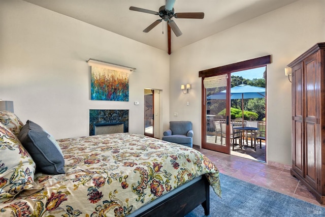 bedroom with ceiling fan, access to outside, a high ceiling, and a premium fireplace