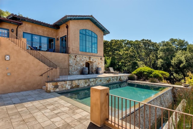 pool with a patio and stairs