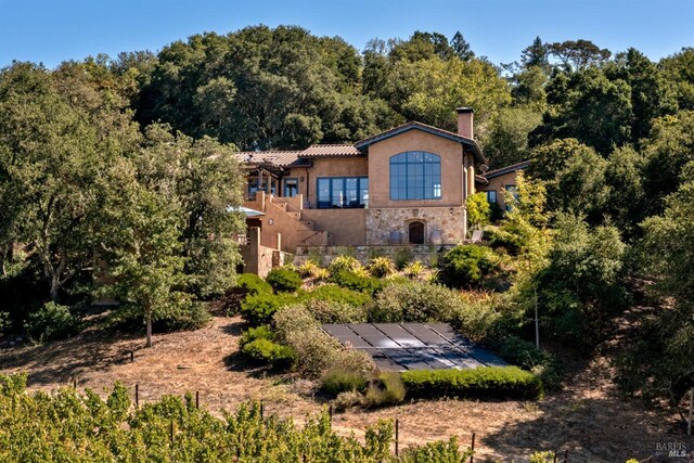 exterior space with stucco siding, stone siding, and a chimney