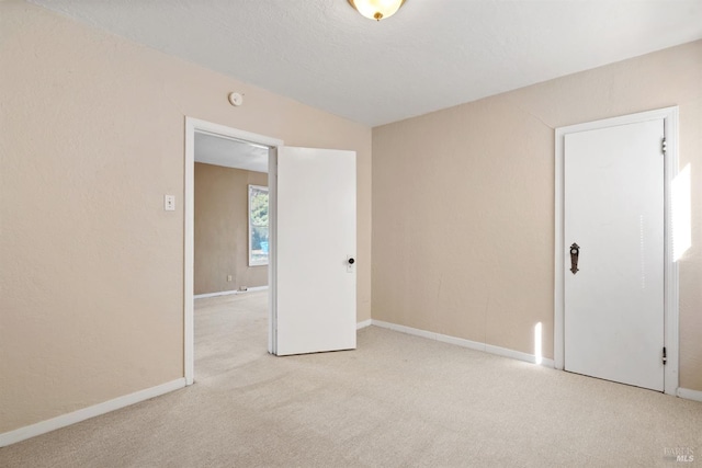carpeted empty room with baseboards