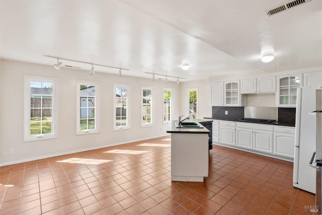 kitchen featuring a sink, dark countertops, tile patterned flooring, and visible vents