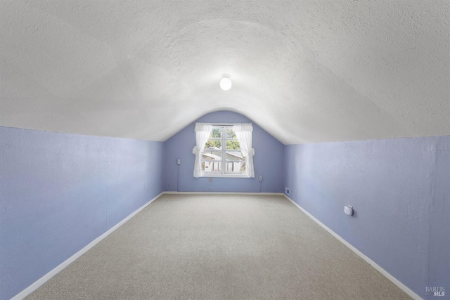 bonus room with baseboards, carpet, lofted ceiling, and a textured ceiling