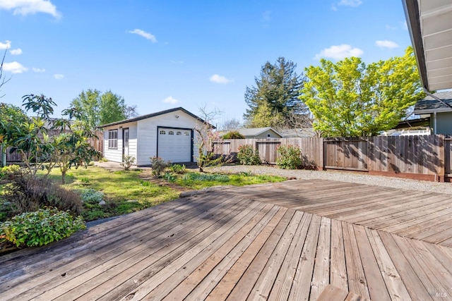 deck featuring an outbuilding, a fenced backyard, and a garage