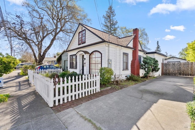 view of front facade featuring a chimney and a fenced front yard