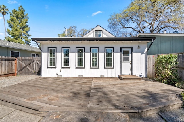 rear view of house with a deck and fence