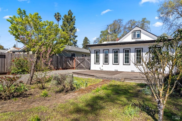 back of house featuring fence and a deck