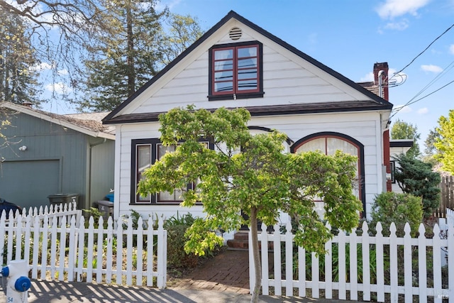 bungalow with a chimney and a fenced front yard
