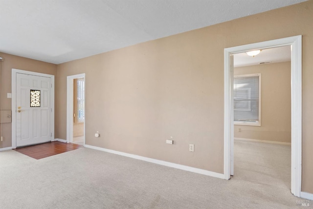 carpeted entrance foyer with baseboards