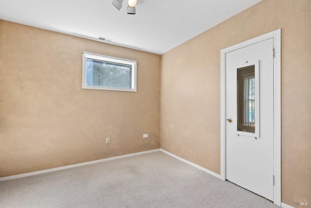 empty room with carpet, visible vents, baseboards, and a ceiling fan