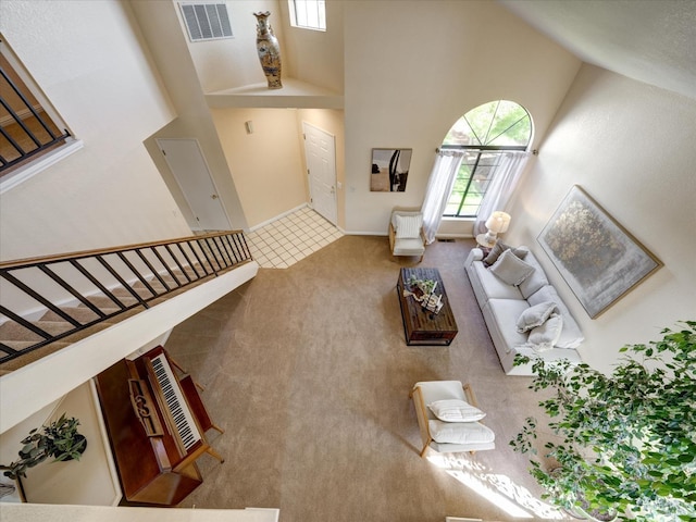 living room with visible vents, a towering ceiling, and carpet floors