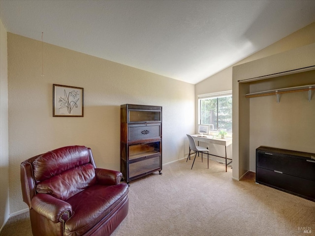 sitting room featuring carpet flooring and vaulted ceiling