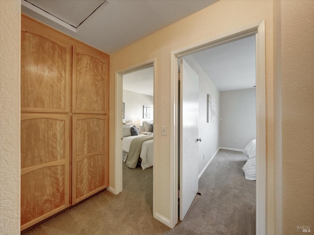 corridor featuring baseboards and carpet
