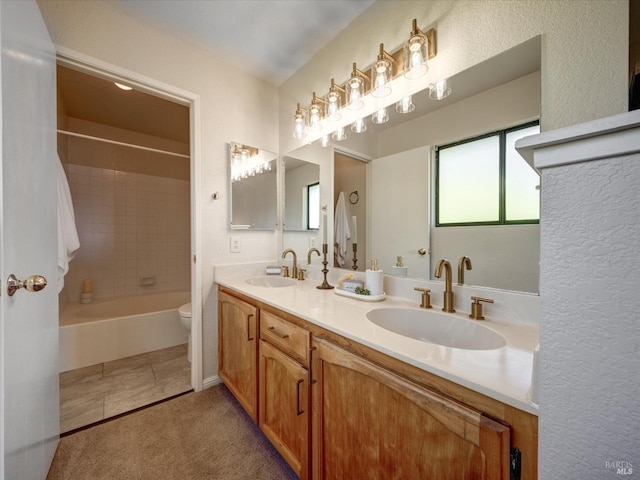 bathroom with a sink, toilet, double vanity, and shower / washtub combination