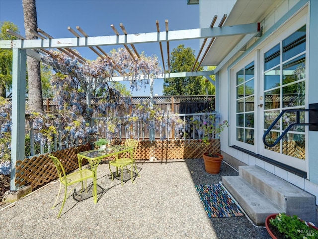 view of patio / terrace featuring french doors, fence, and a pergola