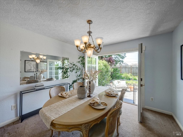 dining area featuring a chandelier, baseboards, a textured ceiling, and carpet floors